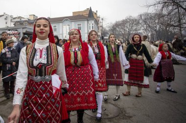 Bulgaristan 'ın Kyustendil kenti - 10 Şubat 2024: Bulgaristan' ın Kyustendil kentinde düzenlenen maskeli balo festivalinin birincisi. Bulgar halk dansları giyinmiş kadınlar doğurganlık ve sağlık ayini düzenliyor..