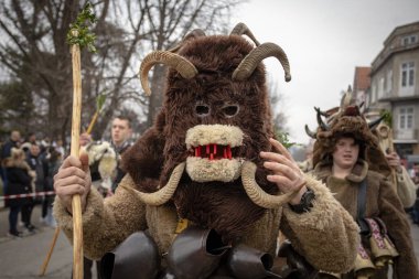 Bulgaristan 'ın Kyustendil kenti - 10 Şubat 2024: Bulgaristan' ın Kyustendil kentinde düzenlenen maskeli balo festivalinin birincisi. Geleneksel Kuker deri takım elbiseli adamlar pirinç çanlar eşliğinde dans ediyor ve doğurganlık ve sağlık ayini yapıyorlar..