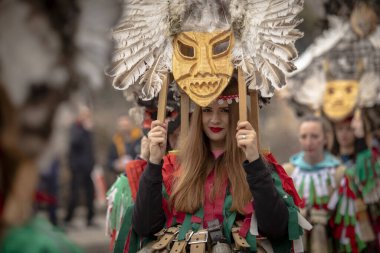 Bulgaristan 'ın Kyustendil kenti - 10 Şubat 2024: Bulgaristan' ın Kyustendil kentinde düzenlenen maskeli balo festivalinin birincisi. Bulgar halk kostüm giymiş kadınlar bakır çanlar eşliğinde dans ediyor ve doğurganlık ve sağlık ayini yapıyorlar.