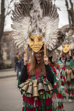Bulgaristan 'ın Kyustendil kenti - 10 Şubat 2024: Bulgaristan' ın Kyustendil kentinde düzenlenen maskeli balo festivalinin birincisi. Bulgar halk kostüm giymiş kadınlar bakır çanlar eşliğinde dans ediyor ve doğurganlık ve sağlık ayini yapıyorlar.