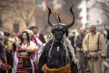 Bulgaristan 'ın Kyustendil kenti - 10 Şubat 2024: Bulgaristan' ın Kyustendil kentinde düzenlenen maskeli balo festivalinin birincisi. Geleneksel Kuker deri takım elbiseli adamlar pirinç çanlar eşliğinde dans ediyor ve doğurganlık ve sağlık ayini yapıyorlar..