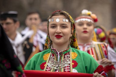 Bulgaristan 'ın Kyustendil kenti - 10 Şubat 2024: Bulgaristan' ın Kyustendil kentinde düzenlenen maskeli balo festivalinin birincisi. Bulgar halk dansları giyinmiş kadınlar doğurganlık ve sağlık ayini düzenliyor..