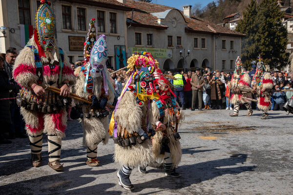 Shiroka Laka, Bulgaria - March 03, 2024: Masked men called Kukeri play and scare away evil spirits at the Pesponedelnik Masquerade Games Festival in Shiroka Laka, Bulgaria