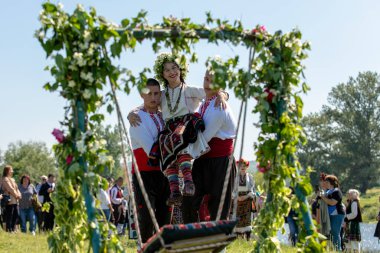 Bulgaristan 'ın Koinare kenti - 28 Nisan 2024: Kumicheneto, Lazarov Günü olarak da bilinir. Geçen yıl kadın olan kızlar saçlarını renkli ve zengin bir şekilde çiçeklerle süslerler..