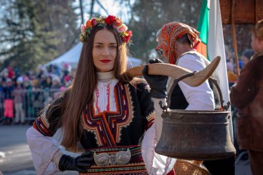 Sofya, Bulgaristan - 05 Ocak 2025: Bulgaristan 'ın Sofya kentinde düzenlenen Surva maskeli oyunlar festivalinde geleneksel kuker kostümlü tanımlanamayan kadın. Bulgaristan 'ın Sofya kentinde düzenlenen maskeli balo oyunlarında Kuker kostümü