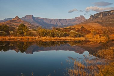 Kraliyet Natal Ulusal Parkı 'ndaki sakin bir Drakensberg Gölü' nde amfitiyatro oluşumunun sabahın erken saatlerindeki yansımaları. KwaZulu-Natal. Güney Afrika
