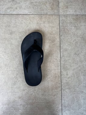 Beton zeminde eski terlikler ve fotokopi alanı. Üst görünüm.