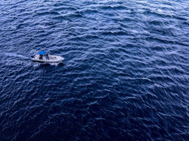 Okyanusta bir tekne. Mavi su drone görünümünde bir tekne..