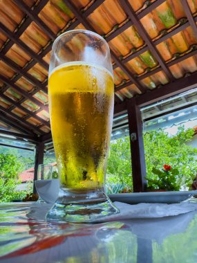 Restoran masasında bir bardak bira. Bira masanın üstünde..