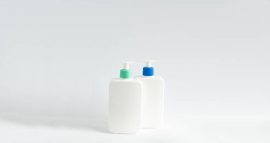 Beyaz arka planda siyah bir şeker kutusuyla markasız iki beyaz şişe. Krem, şampuan, yağ, jöle, sabun, balsam için makyaj şişesi.