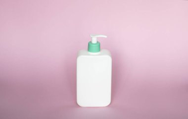 Pembe arka planda izole edilmiş beyaz markasız bir şişe. Kopya alanı ile kozmetik ambalaj modeli. Duş, jöle ve sabun için şişe.