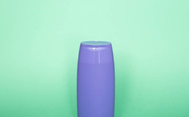 Şampuan, jöle, krem, banyo köpüğü yeşil arka plan için mor, boş, markasız plastik şişe.