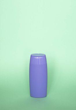 Violet boş şampuan şişesi ya da pastel yeşil arka planda duş jeli. Konteynır, güzellik ürünü ve vücut bakımı kozmetikleri