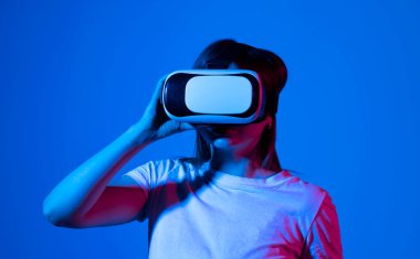 Esmer kadın VR kulaklık kullanarak metaverse konusunda tecrübe kazanıyor. Sanal gerçeklik vasıtasıyla bir siber uzayı keşfetmek