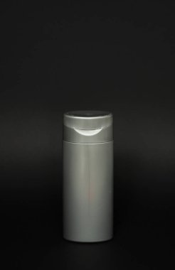 Jöle, losyon, krem, şampuan, banyo köpüğü için gri sıvı kap. Siyah arka planda kozmetik plastik şişe. Kopya alanı ile kozmetik paketleme