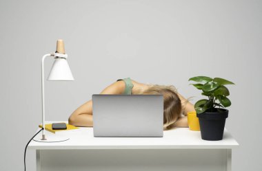 Young frustrated exhausted woman laid her head down on the table sit work at white desk with contemporary pc laptop. Achievement business career concept