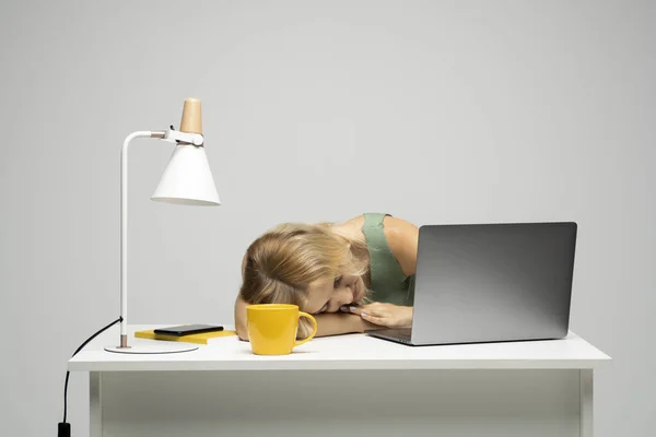 Tired exhausted woman laid her head down on the table sit work at white desk with contemporary pc laptop. Achievement business career concept