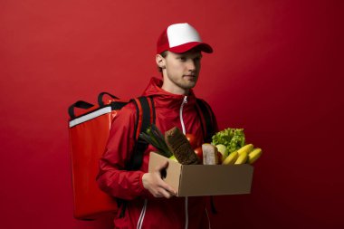 Teslimat Konsepti - Yakışıklı teslimatçı marketten bir paket yiyecek ve içecek getirdi