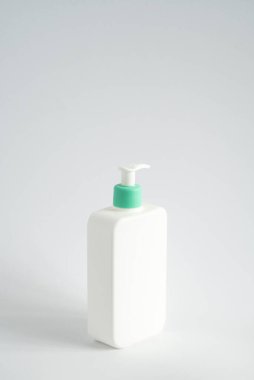 Jöle, losyon, krem, şampuan ve beyaz arka planda banyo köpüğü için sıvı konteynır görevi gören büyük beyaz plastik bir şişe.
