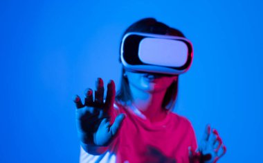 Attractive woman wearing virtual reality goggles. VR headset. Woman using finger to touch on imaginary panel viewing on VR device