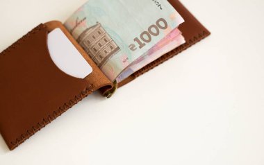 Kahverengi deri para klipsi, içinde Ukrayna Hryvnia banknotları olan çanta. Gerçek deri cüzdan. Aksesuarlar. Para, finans, ekonomi, tasarruf