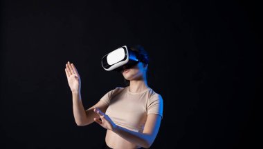 VR kulaklıklı kadın sanal gerçeklikteki nesnelere oyun oynarken ya da 3D film izlerken bakıyor. Gelecekteki teknoloji konsepti