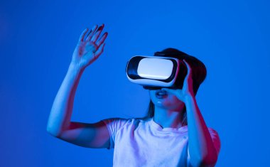 Stüdyoda VR gözlüklü genç bir kadının görüntüsünü yakın plan çekiyoruz. Sanal bir alanda ellerimizle yakınlaşırken metaevrendeki nesnelerle etkileşime giriyoruz. Sanal gerçeklik teknolojisi