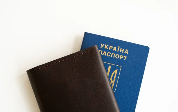 Ukrainian biometric passport id on a leather passport cover to travel the Europe without visas on the table. Inscription in Ukrainian Ukraine Passport