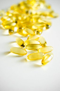 Beyaz bir zemin üzerinde balık yağı takviyesi kapsülleri var. Yağ dolu gıda takviyeleri. Balık yağı, omega 3.