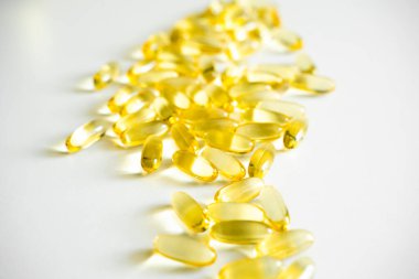 Beyaz masa arkasında Omega 3 kapsülü yığını. Yakın çekim, üst görüş, yüksek çözünürlüklü ürün. Tıbbi hap ya da vitamin kapsülü deseni