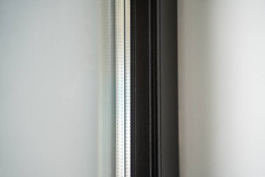 Karanlık desenli yalıtımlı bir pencere sisteminin iç kenarının açılı çekimi, inşa kalitesini ve cila teknolojisini ön plana çıkarıyor..