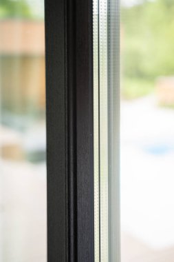 Görünür çift camlı ve delikli boşluk çubuğu ile izole edilmiş pencere sisteminin ayrıntılı görünümü, derinlik ve gölge oluşturur.