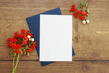 Düğün kartı tebrikleri ve davetiye kartpostalları zarf kopyası, çiçek süslemeli dikey düz kompozisyon ve ahşap arkaplan fotokopi alanı ile şablon oluşturur.