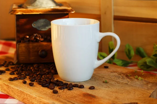 コーヒー豆とヴィンテージコーヒーグラインダー 11Ozドリンクウェアモックアップで木の背景に白いコーヒーマグ ロイヤリティフリーのストック画像