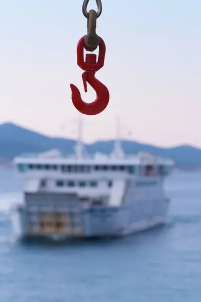 stock image Ferry crane hook close-up and a ferry visible in background. Travel, tourism, sea traffic and transportation concepts