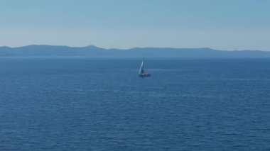 Hırvatistan 'ın Adriyatik Denizi' ndeki Kornati takımadasının Ugljan adası yakınlarındaki bir yelkenliye teknesine yaklaşıyoruz. Seyahat, turizm, tatil, bedava yaşam tarzı ve lüks kavramlar. Hava kaydırağı ve pan drone görüntüsü. 4K 60FPS