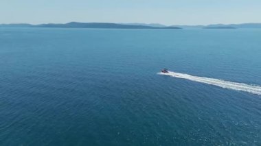 Hırvatistan 'ın Kornati takımadası yakınlarında Adriyatik Denizi' nin dalgalarında süzülen küçük sürat teknesi. Seyahat, turizm, tatil, bedava yaşam tarzı ve lüks kavramlar. Havadan insansız hava aracı atışı. 4K 60FPS