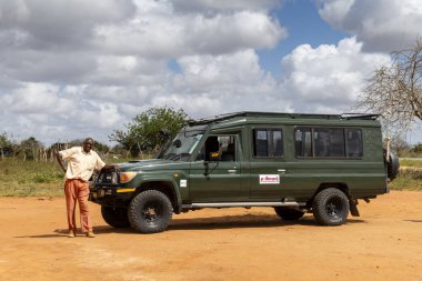Tsavo Est, Kenya, Afrika, 19 Ağustos 2023, Afrika safari rehberi off-road aracının önünde.