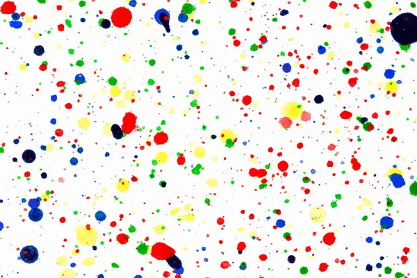 Colorful ink splashes. Paint splatters on bright material. Multi color dots. Watercolor on white paper.