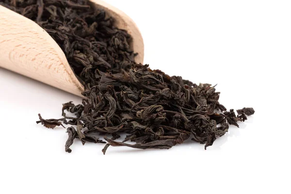 stock image Black tea in a scoop on a black tea background. Close-up shot