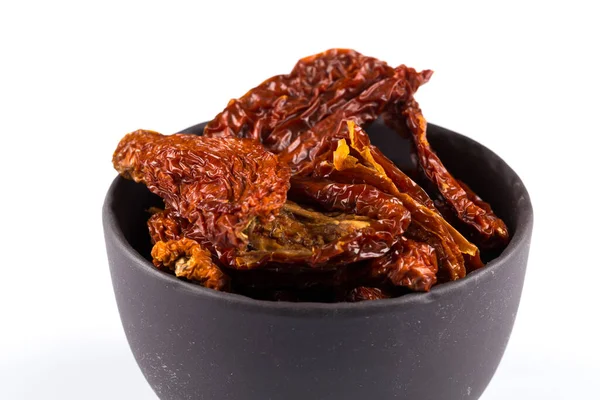 stock image dried tomatoes in stone bowl close up on white background