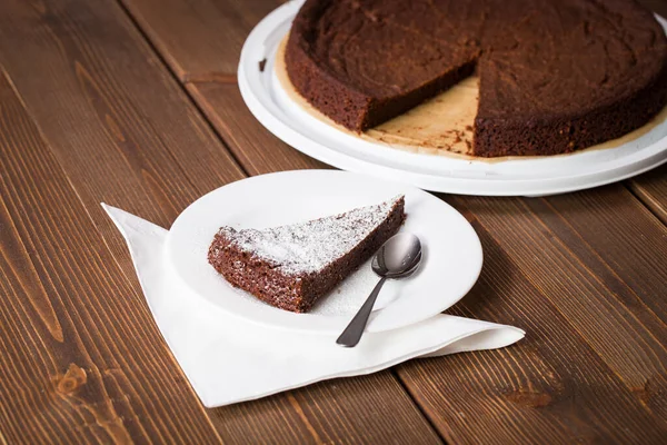 Hausgemachter Schokoladenkuchen Mit Einem Geschnittenen Stück Auf Einem Dunklen Holztisch — Stockfoto