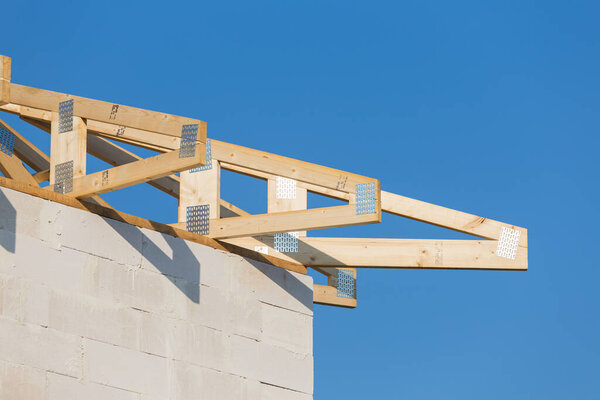 New residential construction roof home framing against a blue sky