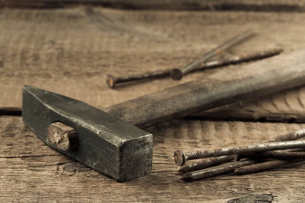 stock image Vintage old hammer with rusty nails on wood table background