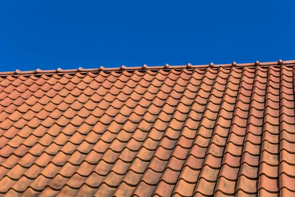 在蓝蓝的天空的红色屋顶平铺模式 — 图库照片
