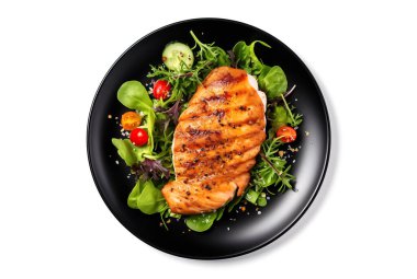 Tavuklu sağlıklı yeşil salata, koyu siyah tabakta servis ediliyor, beyaz arka planda izole edilmiş..