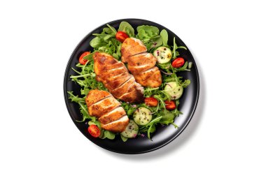 Tavuklu sağlıklı yeşil salata, koyu siyah tabakta servis ediliyor, beyaz arka planda izole edilmiş..
