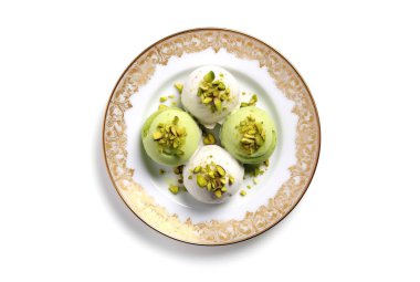 Beyaz arka planda izole edilmiş, tabakta fıstıklı dondurma topu yan ya da ön görünümü.