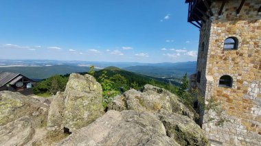 Dağları ve mavi gökyüzü olan bir köy manzarası