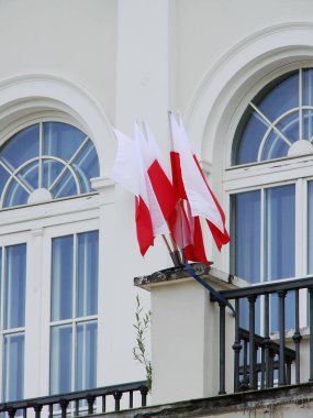 Varşova şehrindeki binanın arka planında ulusal bayraklar